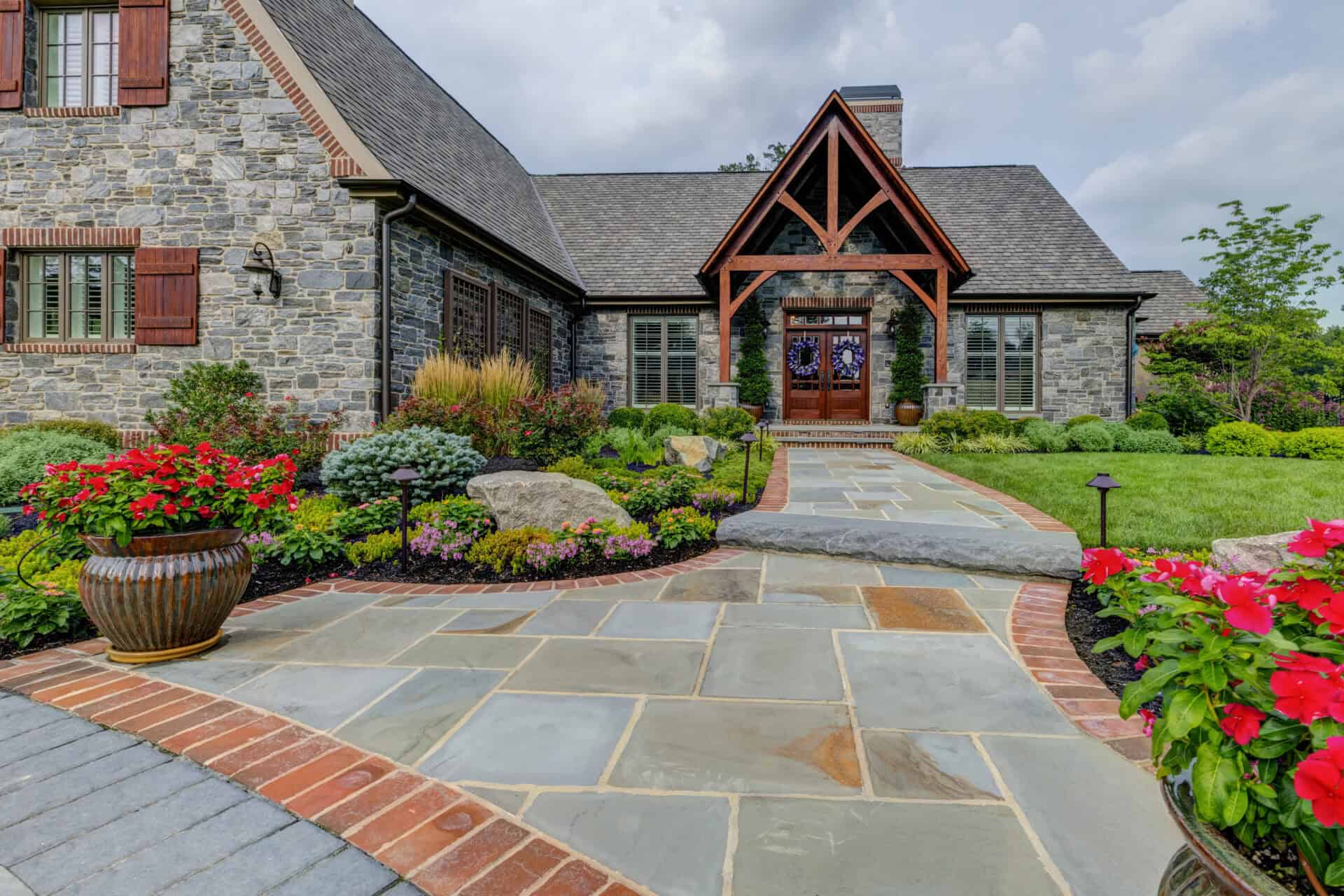 Stone home with timber entry, landscaped garden, and slate walkway in Delaware County, PA